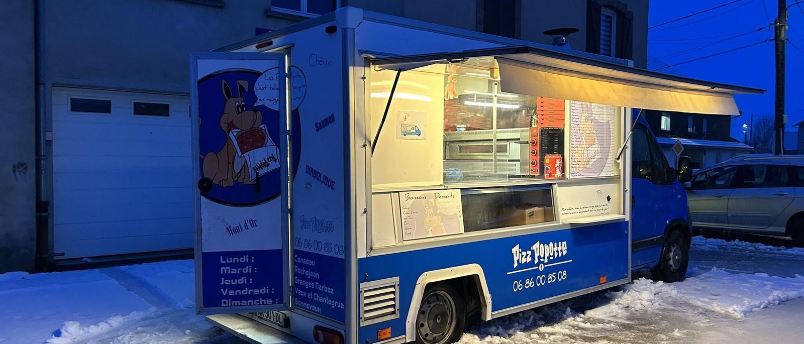 Le camion Pizz'Popotte ouvert et éclairé, un soir de neige