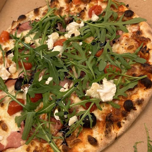 Pizza chèvre, jambon, roquette et tomates cerises